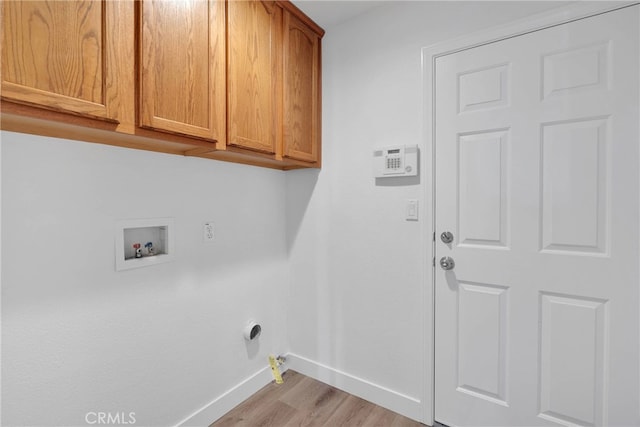 washroom featuring baseboards, gas dryer hookup, cabinet space, washer hookup, and light wood-type flooring