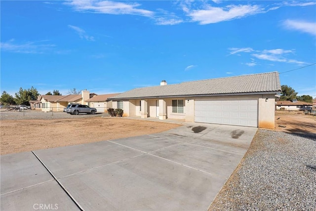 single story home with concrete driveway, a tiled roof, a garage, and stucco siding