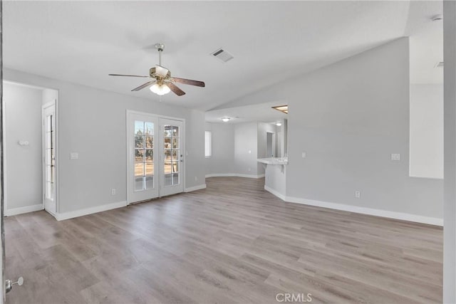 unfurnished living room featuring visible vents, baseboards, ceiling fan, lofted ceiling, and light wood-style flooring