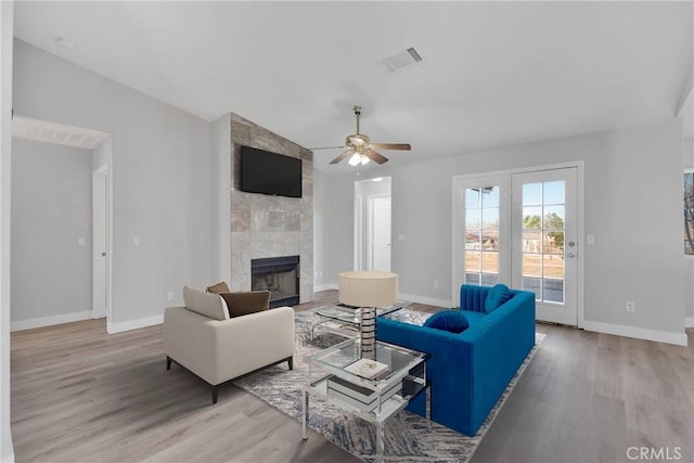 living room featuring baseboards, wood finished floors, and a fireplace