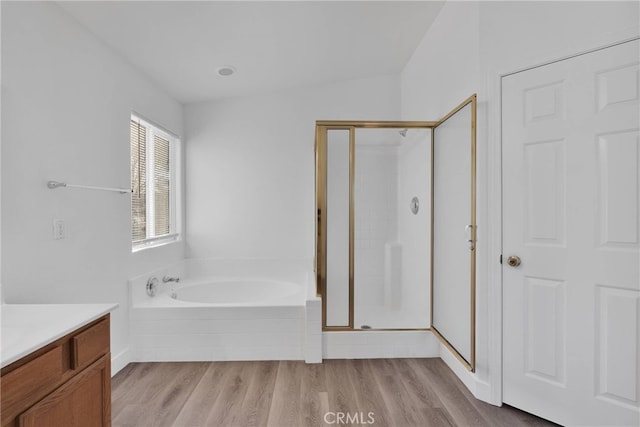 full bath featuring vanity, wood finished floors, a shower stall, and a bath