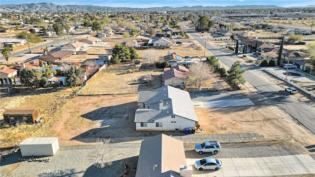 drone / aerial view featuring a residential view, a mountain view, and view of desert