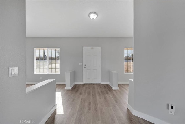 foyer entrance with baseboards and wood finished floors