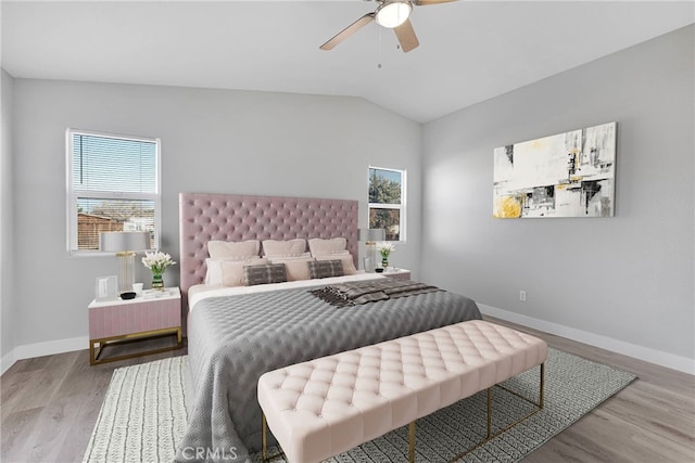 bedroom featuring ceiling fan, baseboards, wood finished floors, and vaulted ceiling