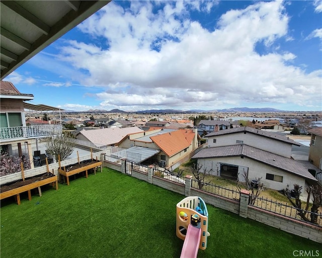 view of yard with a mountain view, a residential view, and a fenced backyard