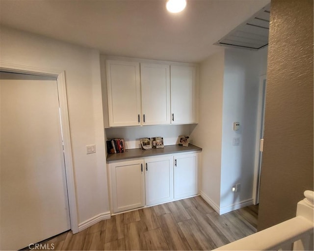 bar featuring baseboards and light wood finished floors