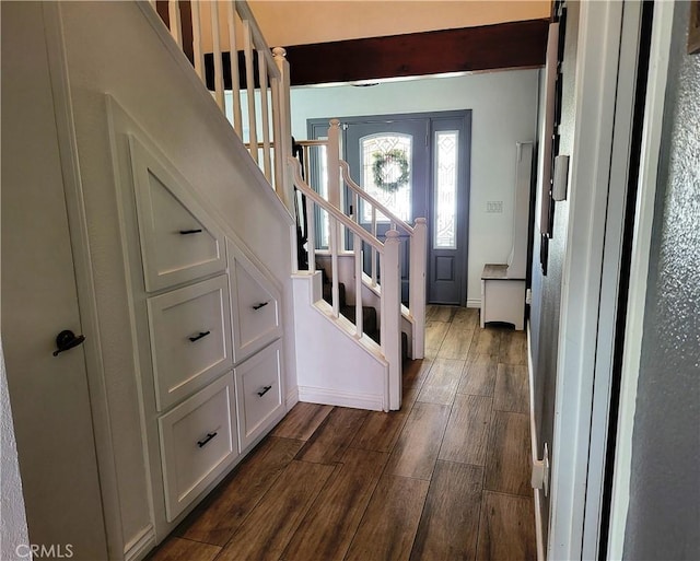 foyer entrance with baseboards, stairs, and wood finish floors