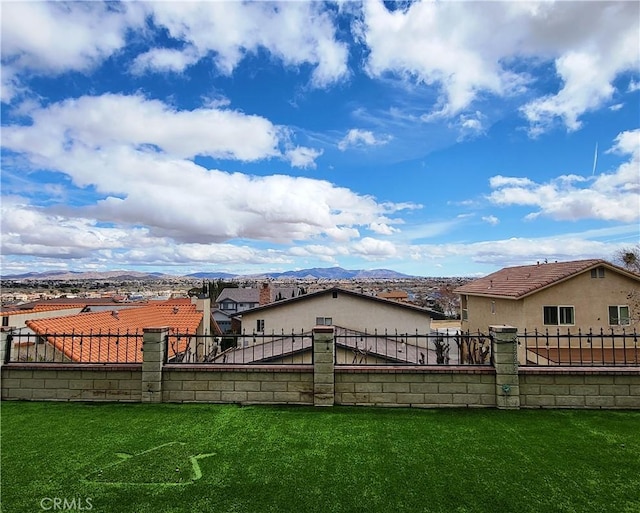 view of yard featuring fence and a mountain view