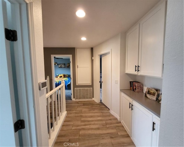 corridor with recessed lighting, visible vents, and light wood finished floors