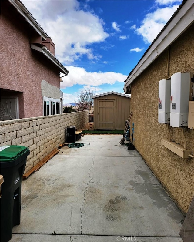 view of patio featuring an outbuilding, a storage shed, and fence