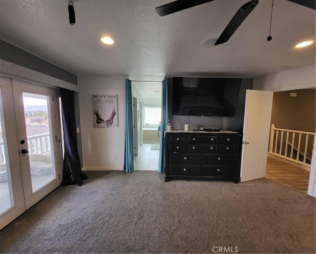 interior space featuring french doors, carpet, a healthy amount of sunlight, and a textured ceiling