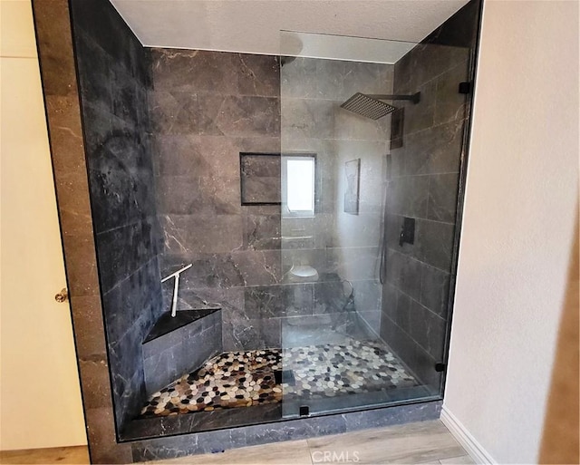 bathroom featuring baseboards and a tile shower