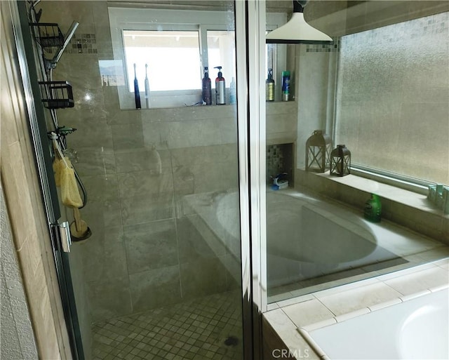 bathroom with a bath and a stall shower