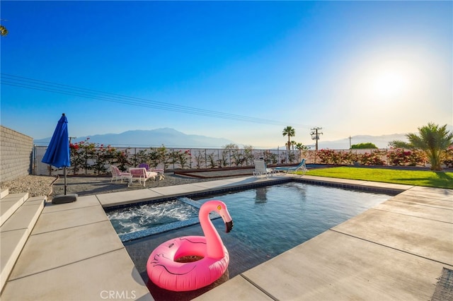 view of pool featuring a fenced in pool, a patio, a mountain view, a fenced backyard, and a lawn