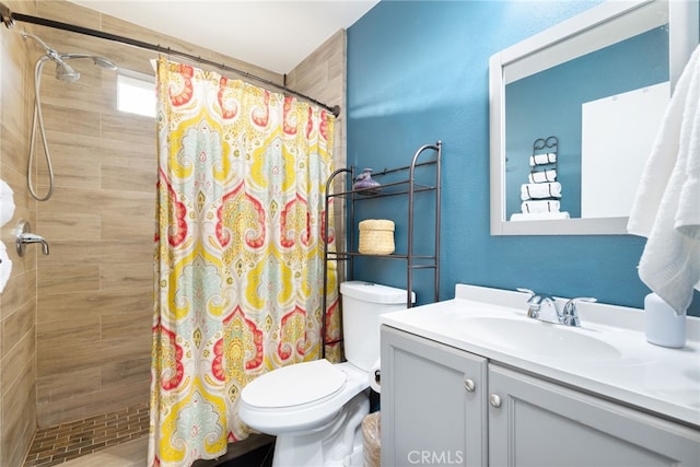 bathroom featuring toilet, a stall shower, and vanity