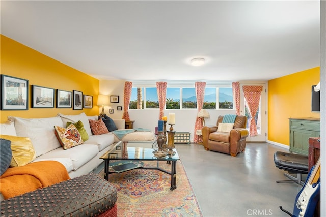 living area with finished concrete flooring and baseboards
