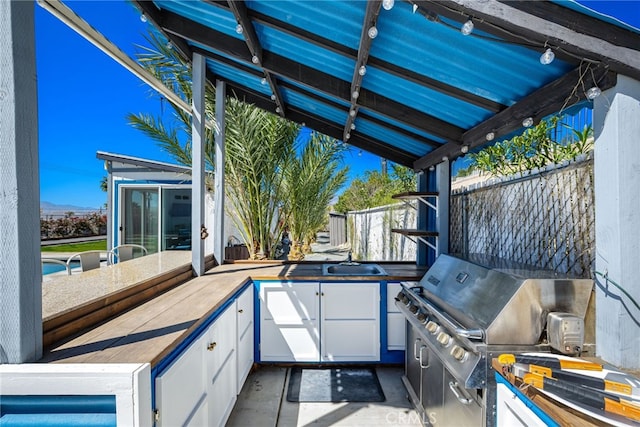 view of patio with a sink, fence, a grill, and area for grilling