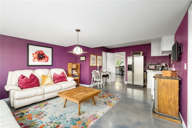 living room with baseboards and concrete flooring