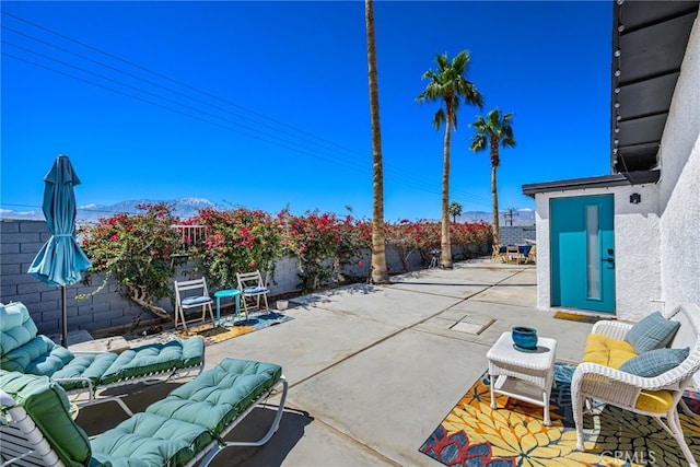 view of patio featuring a mountain view, a fenced backyard, and an outdoor hangout area