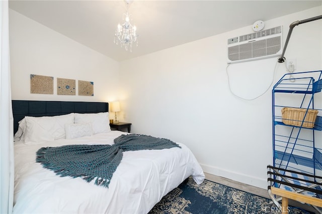 bedroom with baseboards, an inviting chandelier, and a wall mounted air conditioner