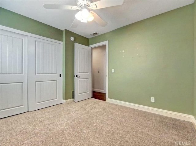 unfurnished bedroom featuring a ceiling fan, baseboards, visible vents, a closet, and carpet flooring