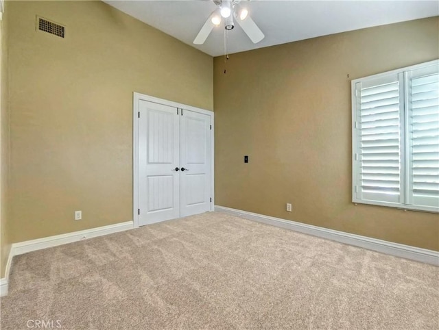 unfurnished bedroom with a closet, visible vents, baseboards, and carpet