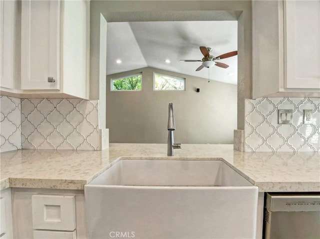 kitchen with a sink, white cabinets, decorative backsplash, and stainless steel dishwasher