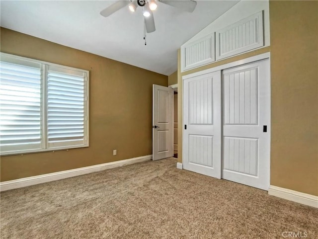 unfurnished bedroom with vaulted ceiling, carpet, a closet, and baseboards