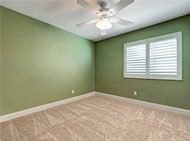 carpeted empty room featuring baseboards and ceiling fan