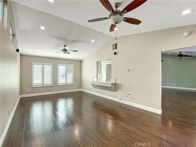 unfurnished living room featuring baseboards, wood finished floors, and vaulted ceiling