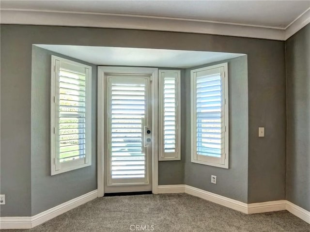 doorway featuring carpet and baseboards