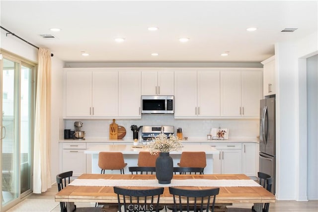 kitchen with white cabinetry, light countertops, visible vents, and appliances with stainless steel finishes