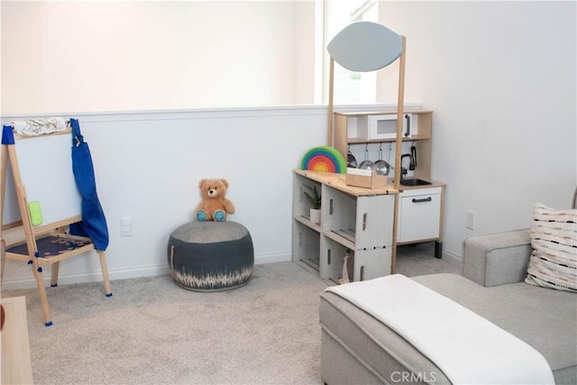 carpeted bedroom featuring baseboards and a sink