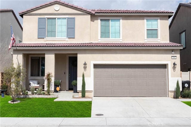 mediterranean / spanish-style house featuring stucco siding, driveway, a front lawn, and a garage