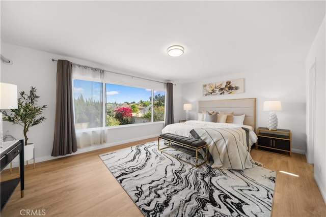 bedroom featuring baseboards and light wood finished floors