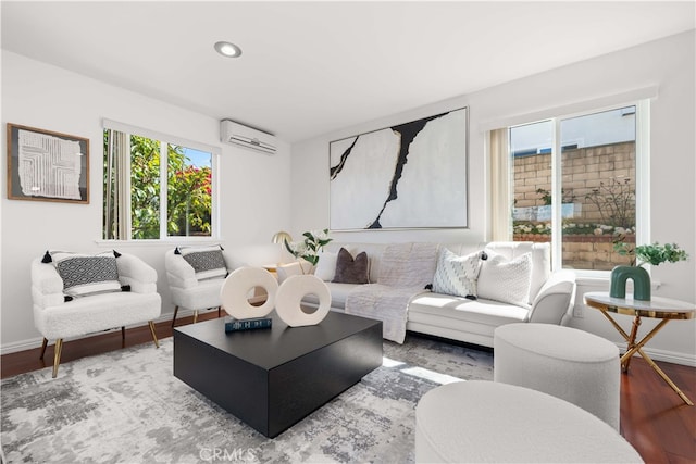 living area featuring recessed lighting, a wall mounted air conditioner, baseboards, and wood finished floors