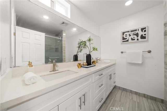 full bath featuring double vanity, visible vents, a shower stall, and a sink