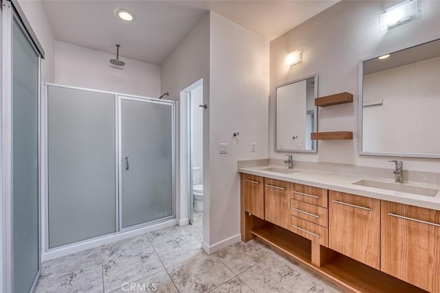 full bathroom featuring double vanity, a stall shower, and a sink