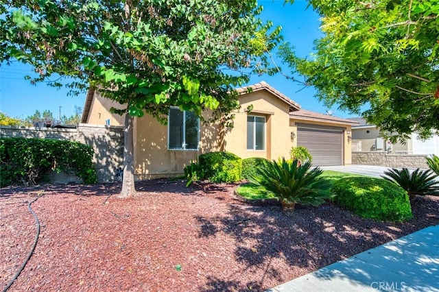 view of front of home featuring a tiled roof, stucco siding, a garage, and fence