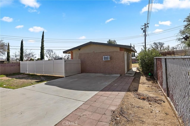 view of side of property with a patio area, fence private yard, and stucco siding