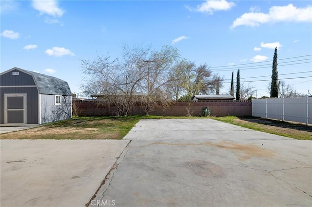 view of patio / terrace featuring an outbuilding, a fenced backyard, and a shed