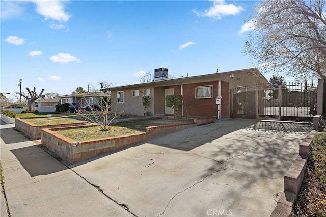 single story home with central AC unit and a gate