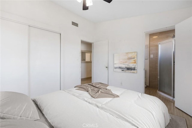 bedroom featuring a closet, visible vents, wood finished floors, and a ceiling fan