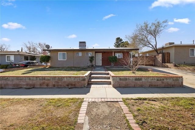 ranch-style house featuring central air condition unit and stucco siding