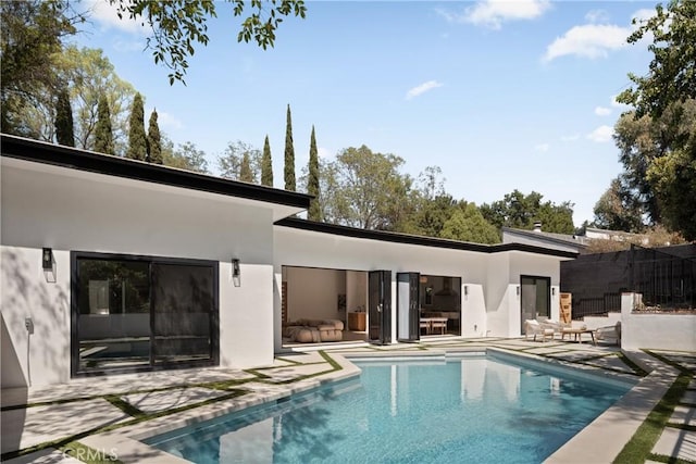 back of property with a fenced in pool, stucco siding, a patio, and fence