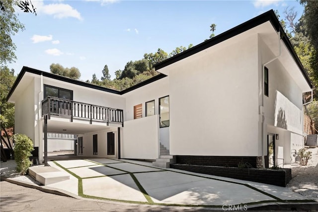 view of front of home with stucco siding and a balcony