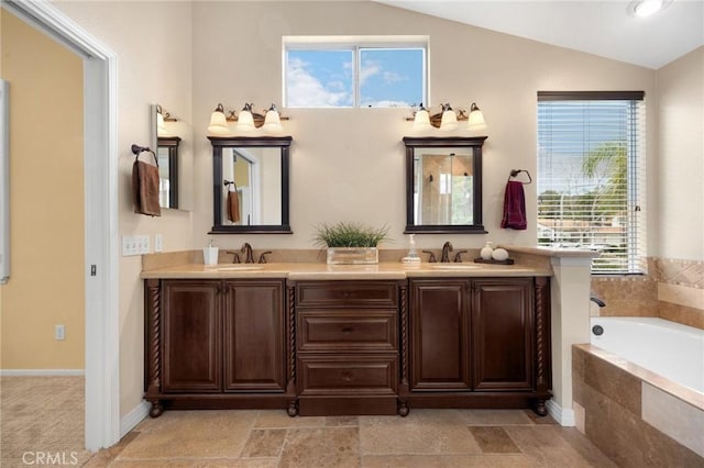 full bath with lofted ceiling, a bath, double vanity, and a sink