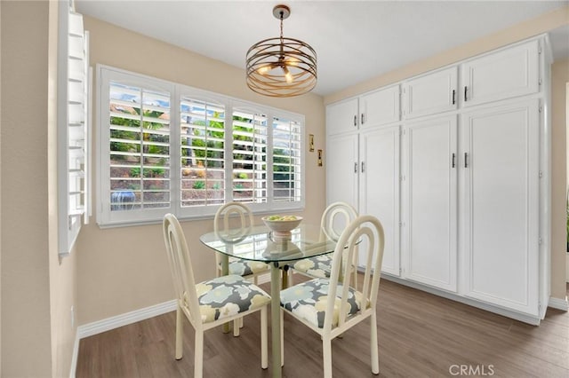 dining area with baseboards, light wood-type flooring, and a chandelier