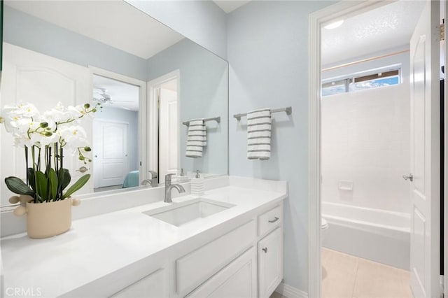 bathroom featuring toilet, connected bathroom, tile patterned flooring, baseboards, and vanity