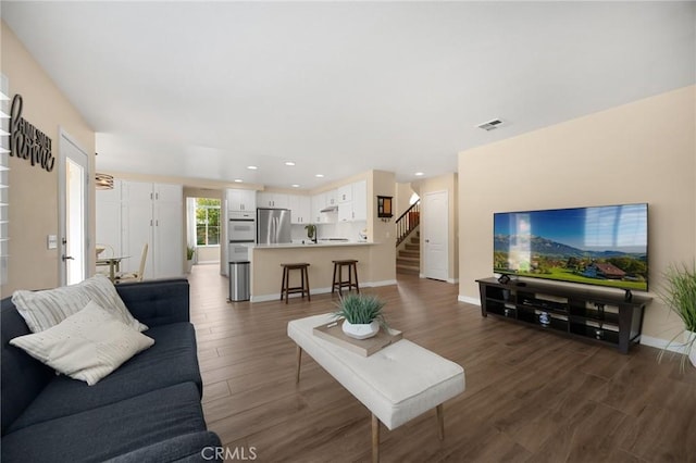 living room with visible vents, baseboards, dark wood finished floors, stairs, and recessed lighting